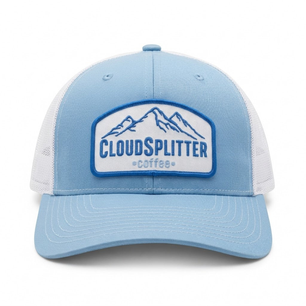 A light blue and white trucker hat with a front patch logo reading 'CLOUDSPLITTER coffee' and a mountain graphic, shown on a clean white background.