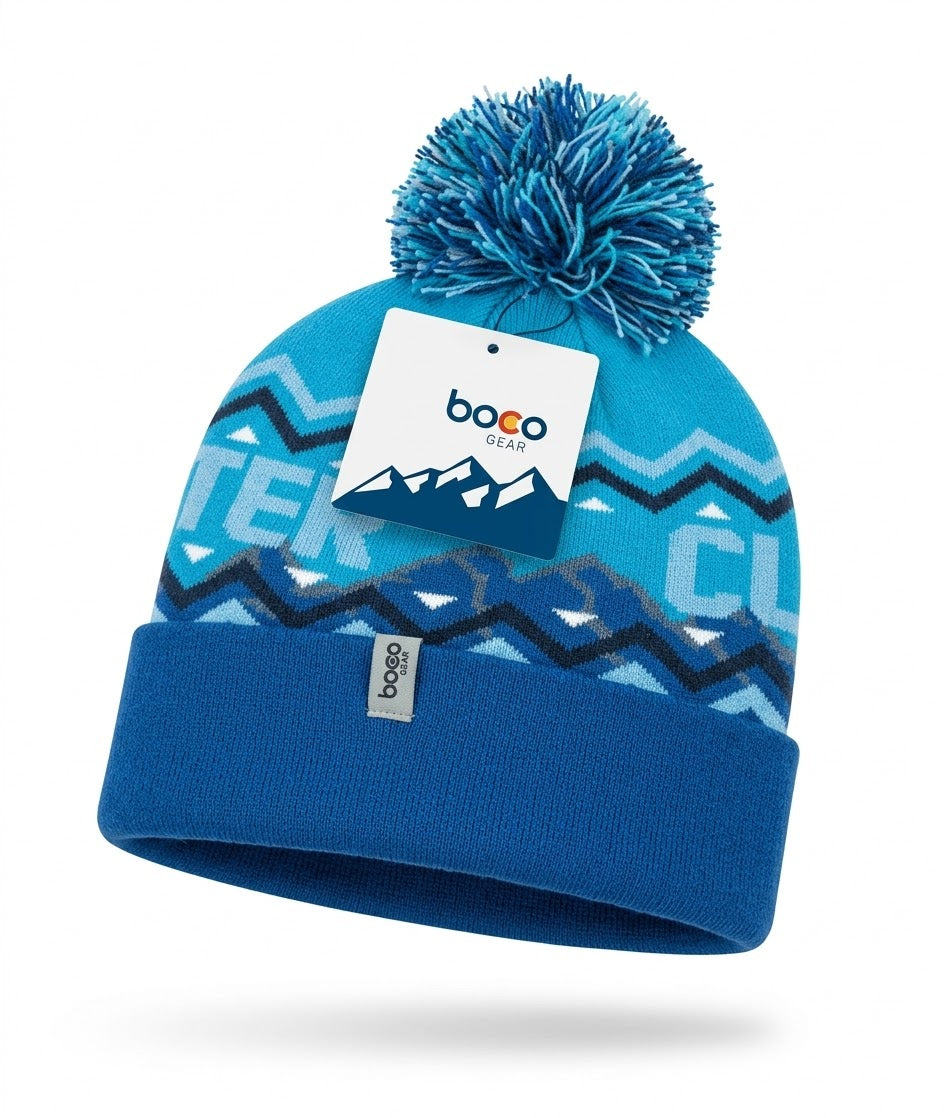 A blue and turquoise knit beanie hat with a matching pom-pom, featuring geometric patterns, a folded cuff, and a white Boco Gear brand tag attached near the top.