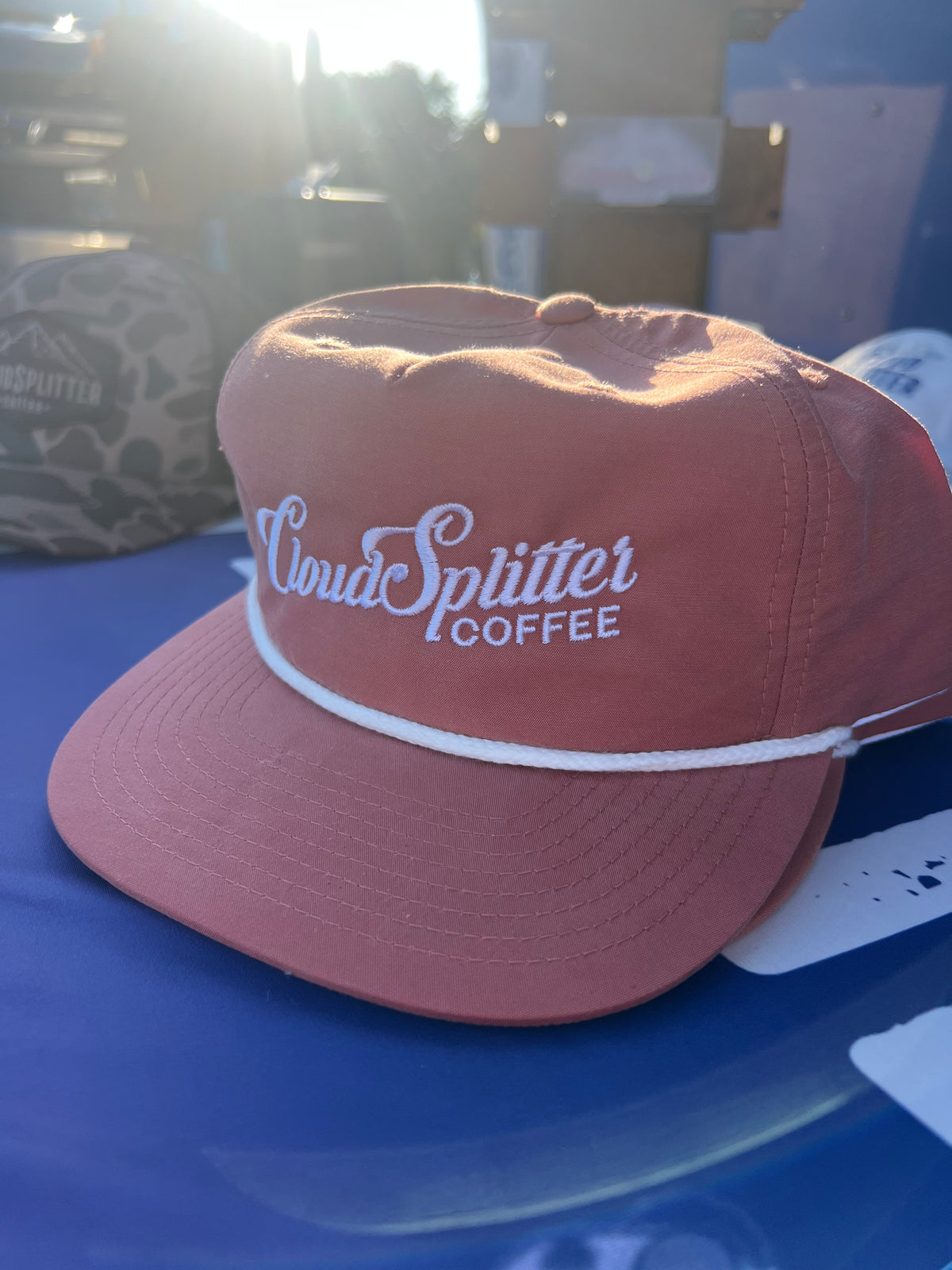 Rose gold 5 panel hat with white accent rope and "CloudSplitter Coffee" embroidered in white script.